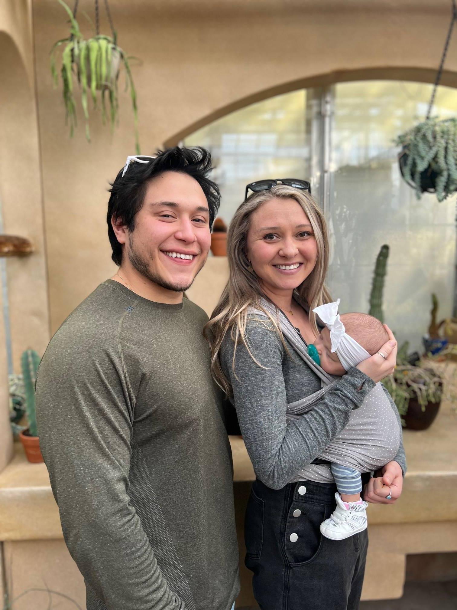 Douglas Ayers smiling with his wife 丹尼尔le as they hold their new baby girl, 咏叹调